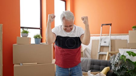 Photo for Middle age man with grey hair celebrating in the room at new home - Royalty Free Image