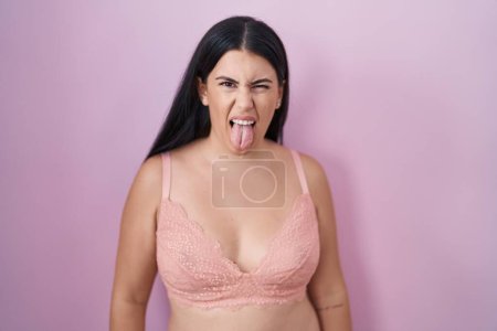 Photo for Young hispanic woman wearing pink bra sticking tongue out happy with funny expression. emotion concept. - Royalty Free Image