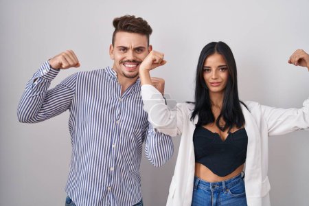 Photo for Young hispanic couple standing over white background showing arms muscles smiling proud. fitness concept. - Royalty Free Image