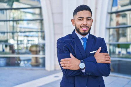 Photo for Young latin man business worker smiling confident standing with arms crossed gesture at street - Royalty Free Image