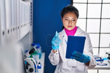 Photo for Young chinese woman scientist having video call at laboratory - Royalty Free Image
