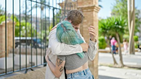 Téléchargez les photos : Man and woman couple hugging each other at street - en image libre de droit