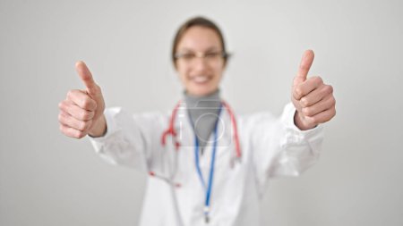 Foto de Joven mujer caucásica médico haciendo pulgares hacia arriba sobre fondo blanco aislado - Imagen libre de derechos