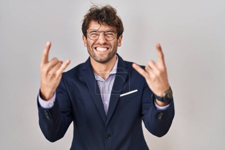 Photo for Hispanic business man wearing glasses shouting with crazy expression doing rock symbol with hands up. music star. heavy concept. - Royalty Free Image
