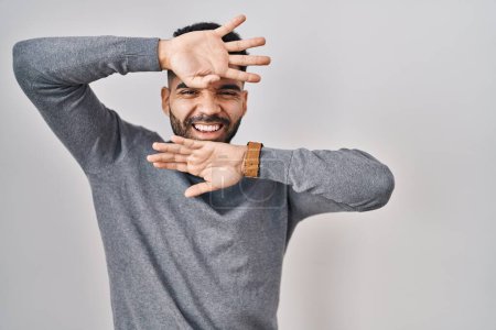 Téléchargez les photos : Hispanic man with beard standing over white background smiling cheerful playing peek a boo with hands showing face. surprised and exited - en image libre de droit