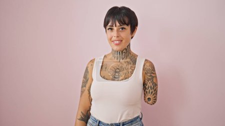 Spanierin mit amputiertem Arm lächelt selbstbewusst vor isoliertem rosa Hintergrund
