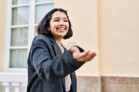 Téléchargez les photos : Jeune femme souriante confiante parlant dans la rue - en image libre de droit