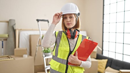 Photo for Young blonde woman architect holding clipboard at new home - Royalty Free Image