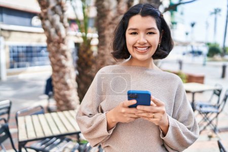 Photo for Young woman smiling confident using smartphone at street - Royalty Free Image