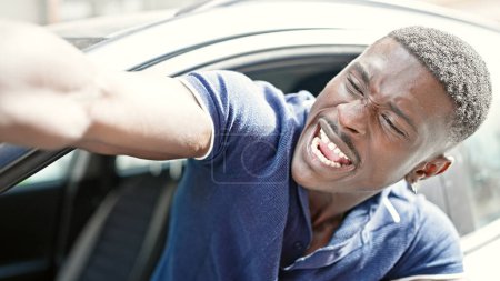 Téléchargez les photos : Afro-Américain souligné voiture de conduite criant à la rue - en image libre de droit