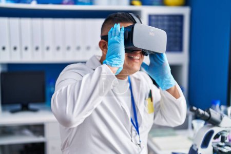 Foto de Joven científico latino usando gafas de realidad virtual en laboratorio - Imagen libre de derechos
