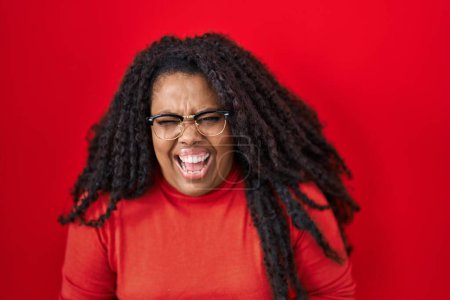 Photo for Plus size hispanic woman standing over red background smiling and laughing hard out loud because funny crazy joke with hands on body. - Royalty Free Image