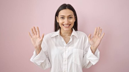 Photo for Young beautiful hispanic woman smiling confident standing with hands raised up over isolated pink background - Royalty Free Image