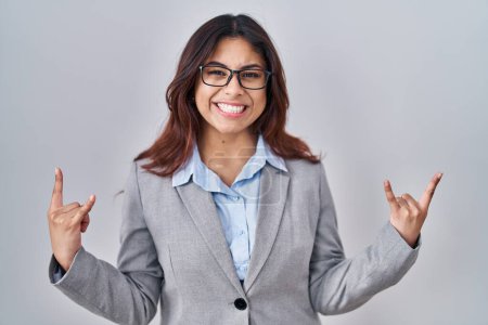 Photo for Hispanic young business woman wearing glasses shouting with crazy expression doing rock symbol with hands up. music star. heavy concept. - Royalty Free Image