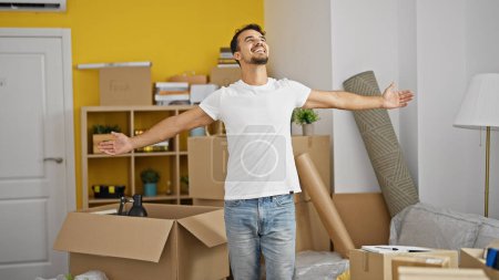 Photo for Young hispanic man smiling confident standing with arms open at new home - Royalty Free Image