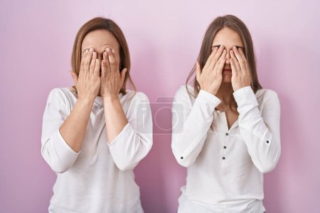 Photo for Middle age mother and young daughter standing over pink background rubbing eyes for fatigue and headache, sleepy and tired expression. vision problem - Royalty Free Image