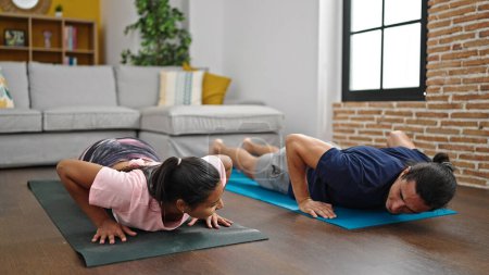 Photo for Man and woman couple training push up smiling at home - Royalty Free Image