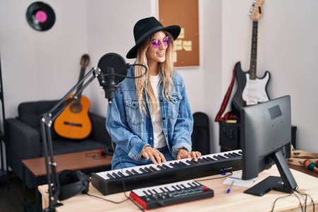 Téléchargez les photos : Young woman musician singing song playing piano keyboard at music studio - en image libre de droit