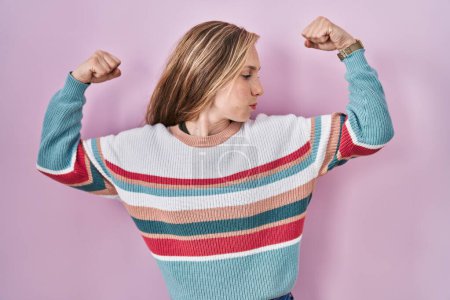 Photo for Young blonde woman standing over pink background showing arms muscles smiling proud. fitness concept. - Royalty Free Image
