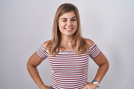 Téléchargez les photos : Jeune femme hispanique debout sur fond isolé clin d'oeil en regardant la caméra avec une expression sexy, gai et heureux visage. - en image libre de droit