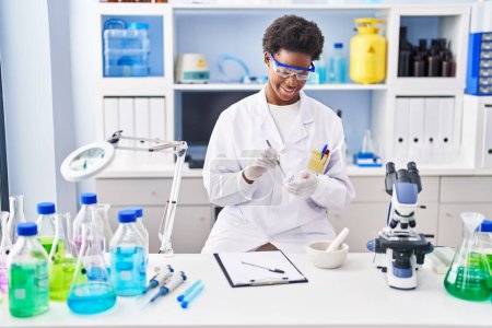 Téléchargez les photos : Femme afro-américaine portant un uniforme de scientifique travaillant au laboratoire - en image libre de droit
