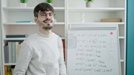 Photo for Young hispanic man teacher teaching maths lesson at university classroom - Royalty Free Image
