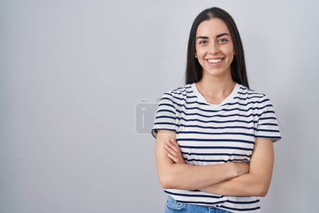 Téléchargez les photos : Jeune femme brune portant t-shirt rayé heureux visage souriant avec les bras croisés en regardant la caméra. personne positive. - en image libre de droit