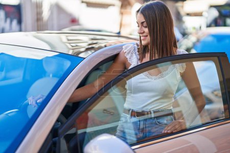 Photo for Young beautiful hispanic woman smiling confident opening car door at street - Royalty Free Image