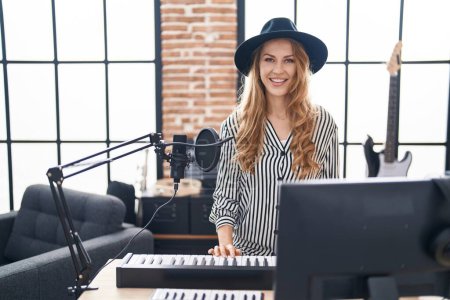 Téléchargez les photos : Young blonde woman musician playing piano keyboard at music studio - en image libre de droit