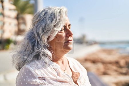 Photo for Middle age woman breathing at seaside - Royalty Free Image