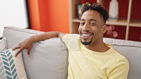 Photo for African american man smiling confident sitting on sofa at home - Royalty Free Image
