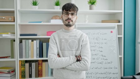 Photo for Young hispanic man standing by white board at university classroom - Royalty Free Image