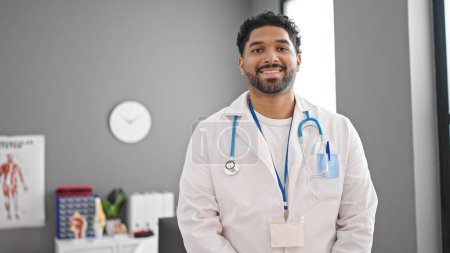 Téléchargez les photos : Afro-américain homme médecin souriant confiance debout à la clinique - en image libre de droit