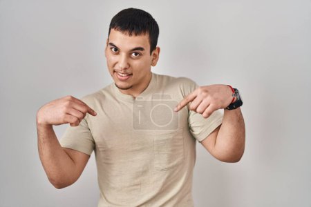 Foto de Hombre árabe joven vistiendo camiseta casual mirando confiado con sonrisa en la cara, señalándose con los dedos orgullosos y felices. - Imagen libre de derechos