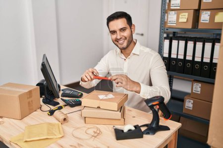Téléchargez les photos : Jeune homme hispanique e-commerce travailleur d'affaires faire une photo à l'emballage au bureau - en image libre de droit