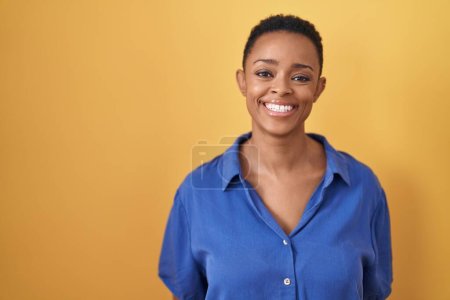 Photo for African american woman standing over yellow background with a happy and cool smile on face. lucky person. - Royalty Free Image