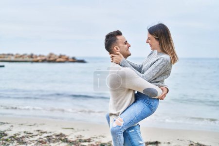 Foto de Hombre y mujer pareja abrazándose uno al otro sosteniéndose de brazos en la playa - Imagen libre de derechos