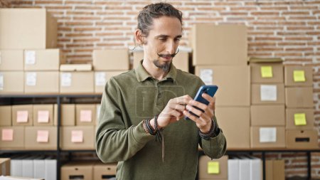 Téléchargez les photos : Young hispanic man ecommerce business worker using smartphone at office - en image libre de droit