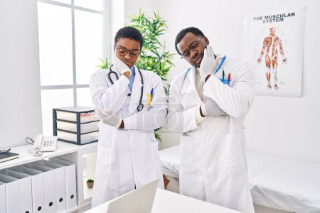Téléchargez les photos : Jeunes médecins afro-américains travaillant à la clinique médicale pensant fatigués et ennuyés par les problèmes de dépression avec les bras croisés. - en image libre de droit