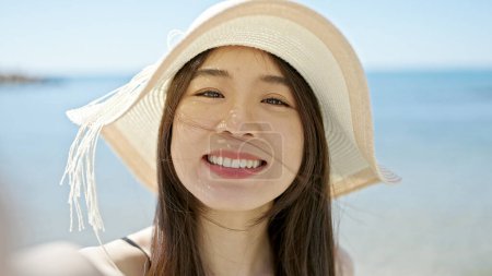 Téléchargez les photos : Jeune femme chinoise touriste portant maillot de bain faire selfie par caméra au bord de la mer - en image libre de droit