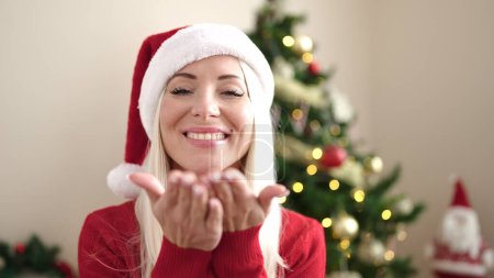 Téléchargez les photos : Jeune femme blonde debout près arbre de Noël baisers à la maison - en image libre de droit