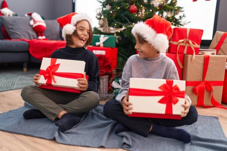 Photo for Adorable boys celebrating christmas unpacking gift at home - Royalty Free Image