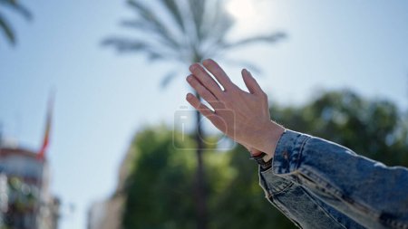 Photo for Young hispanic man with hands raised towards sky at park - Royalty Free Image
