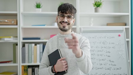 Photo for Young hispanic man teacher standing pointing to camera at university classroom - Royalty Free Image