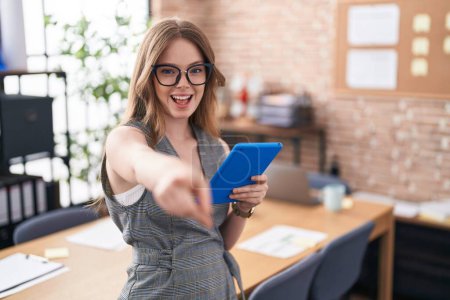 Téléchargez les photos : Femme caucasienne travaillant au bureau portant des lunettes pointant vers vous et la caméra avec les doigts, souriant positif et joyeux - en image libre de droit