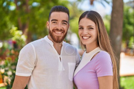 Téléchargez les photos : Homme et femme couple souriant confiant se serrant dans ses bras au parc - en image libre de droit