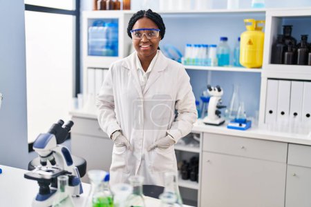 Foto de Mujer científica afroamericana sonriendo confiada de pie en el laboratorio - Imagen libre de derechos