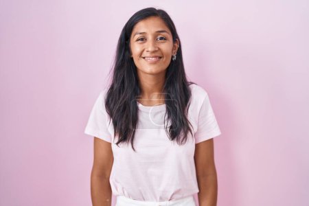 Téléchargez les photos : Jeune femme hispanique debout sur fond rose avec un sourire heureux et cool sur le visage. chanceux. - en image libre de droit