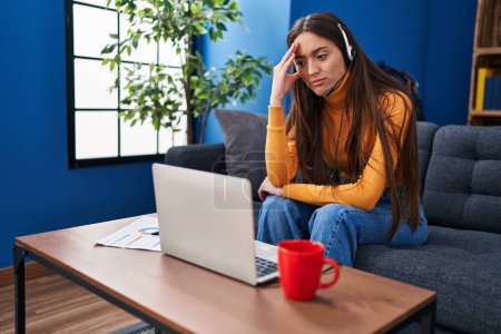 Photo for Young beautiful hispanic woman stressed having video call sitting on sofa at home - Royalty Free Image