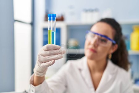 Photo for Young beautiful hispanic woman scientist holding test tubes at laboratory - Royalty Free Image